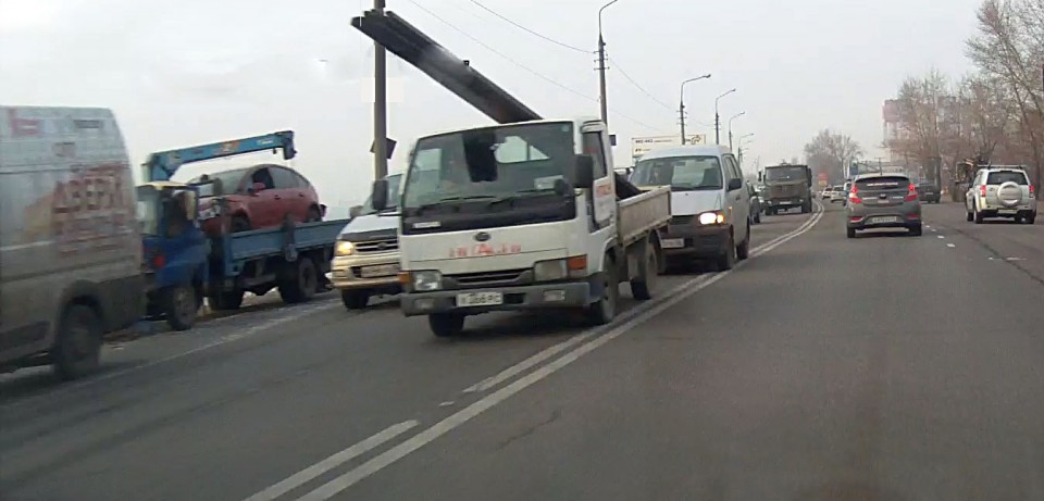 Эвакуатор на встречной полосе убирает пострадавший автомобиль.